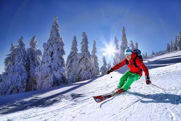 Skier carving down a snowy mountain slope