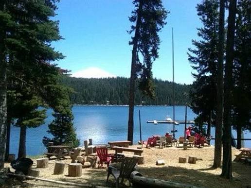 Clear alpine lake with pine trees and mountains